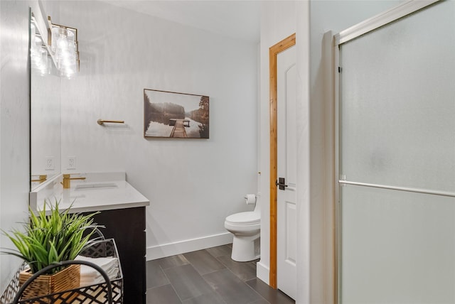 310 Jossie Ln, Kalispell, MT 59901 - bathroom featuring vanity, toilet, a shower stall, and baseboards