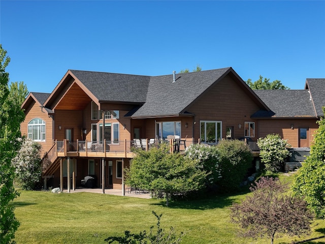 310 Jossie Ln, Kalispell, MT 59901 - back of house featuring a patio, a lawn, a deck, stairway, and a shingled roof