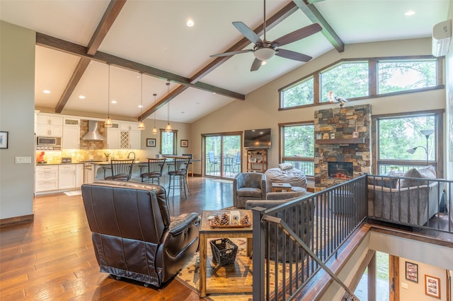 161 Hastings Trl, Columbia Falls, MT 59912 - living area featuring beamed ceiling, hardwood / wood-style flooring, a stone fireplace, ceiling fan, and high vaulted ceiling