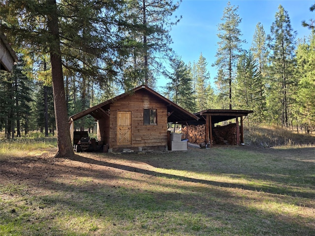 226 Powerline Way, Libby, MT 59923 - view of side of home featuring a yard, an outbuilding, and a forest view