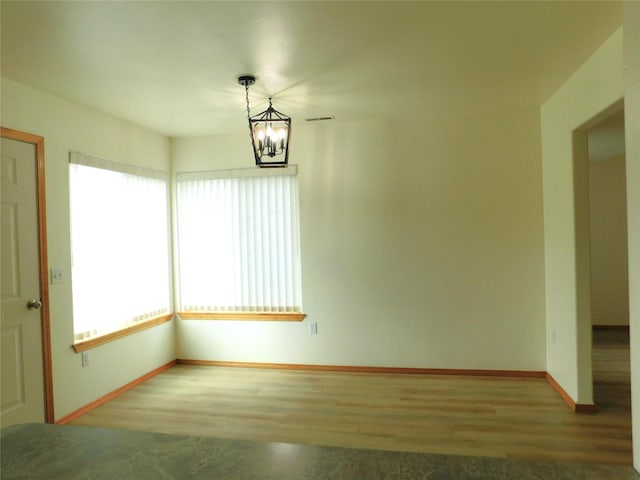 1960/1962 Greatview Dr, Kalispell, MT 59901 - spare room featuring wood finished floors, baseboards, and a chandelier
