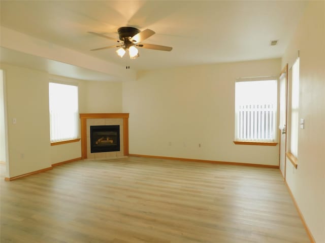1960/1962 Greatview Dr, Kalispell, MT 59901 - unfurnished living room featuring light wood-style flooring, baseboards, a tiled fireplace, and a ceiling fan