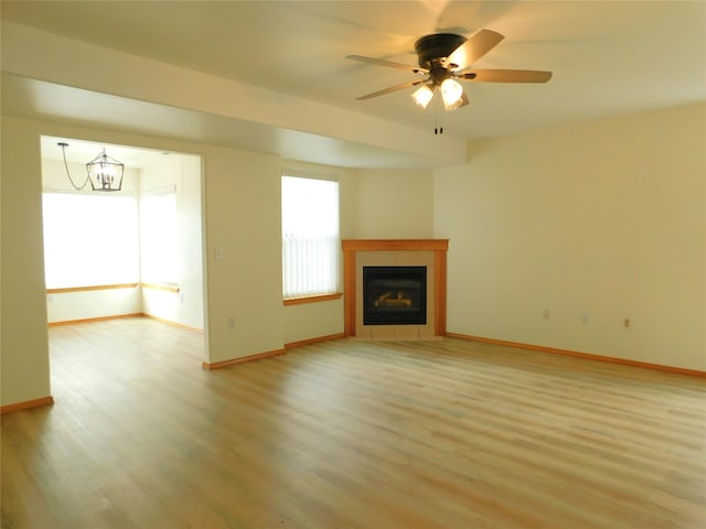 1960/1962 Greatview Dr, Kalispell, MT 59901 - unfurnished living room with light wood-style flooring, baseboards, a tile fireplace, and a ceiling fan