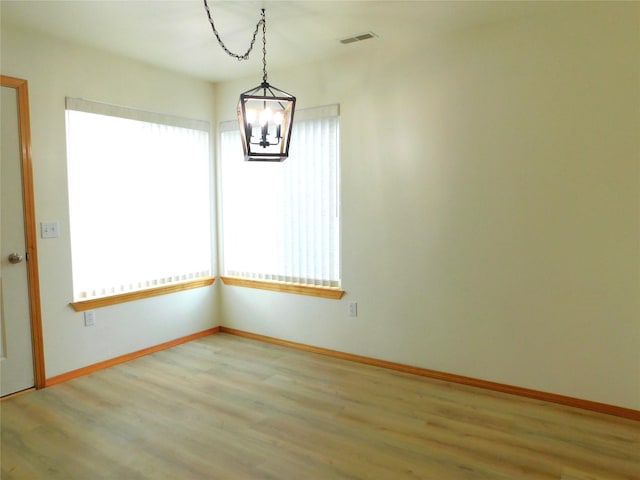 1960/1962 Greatview Dr, Kalispell, MT 59901 - spare room featuring a chandelier, healthy amount of natural light, wood finished floors, and baseboards