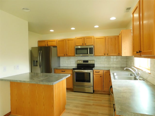 1960/1962 Greatview Dr, Kalispell, MT 59901 - kitchen featuring stainless steel appliances, a sink, light wood-style floors, decorative backsplash, and a peninsula