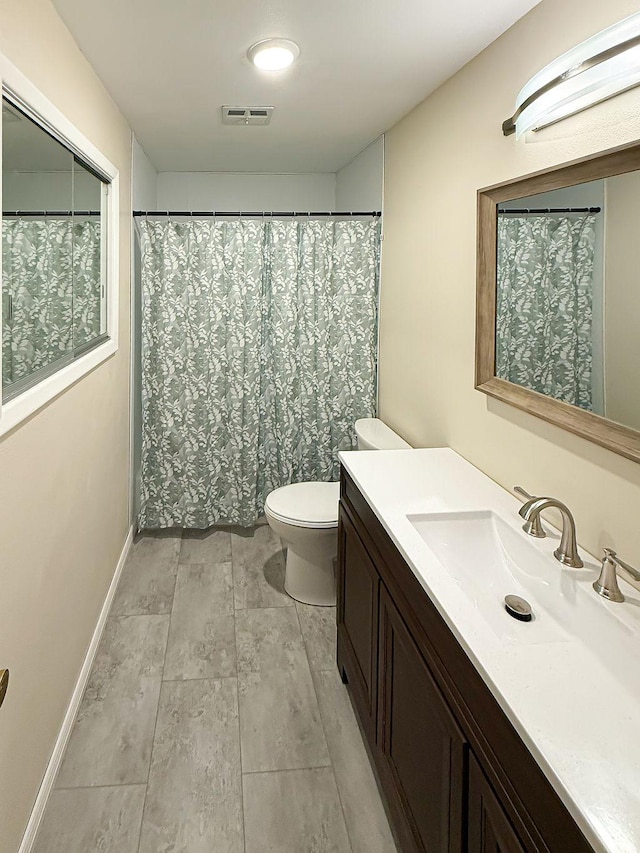 2201 6th Ave N, Great Falls, MT 59401 - bathroom with vanity, toilet, and baseboards