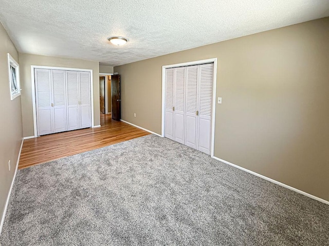 2201 6th Ave N, Great Falls, MT 59401 - unfurnished bedroom featuring carpet flooring, baseboards, a textured ceiling, and two closets