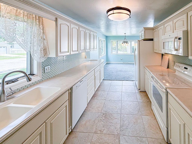 2201 6th Ave N, Great Falls, MT 59401 - kitchen with white appliances, cream cabinetry, a sink, tasteful backsplash, and light countertops