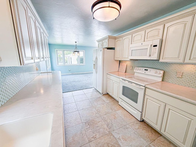2201 6th Ave N, Great Falls, MT 59401 - kitchen with white appliances, cream cabinets, light countertops, backsplash, and light carpet
