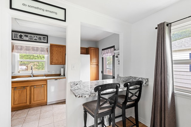 2713 5th Ave S, Great Falls, MT 59405 - kitchen with white appliances, a sink, brown cabinets, light stone counters, and ornamental molding