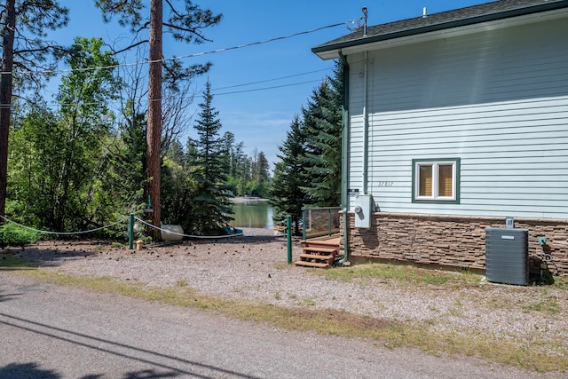 37817 Kings Point Rd, Polson, MT 59860 - view of side of home with stone siding and central AC unit