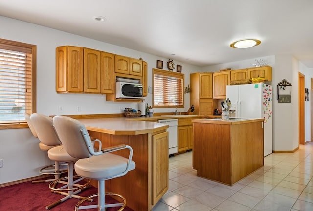 37817 Kings Point Rd, Polson, MT 59860 - kitchen with white appliances, a peninsula, light countertops, and a kitchen bar