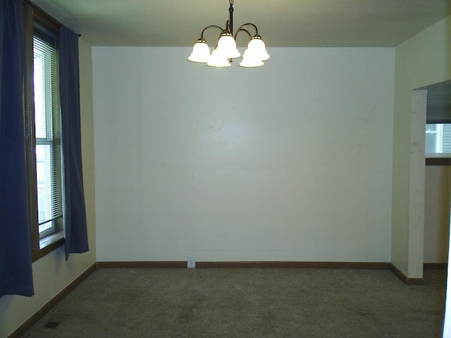619 E Broadway St, Helena, MT 59601 - empty room with dark colored carpet, a chandelier, and plenty of natural light