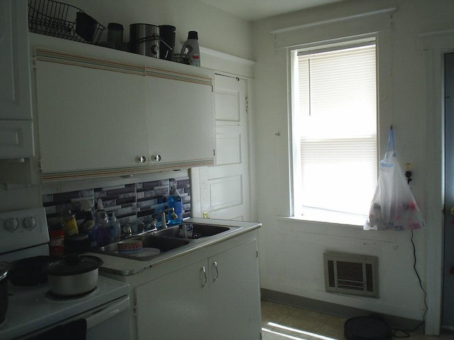 619 E Broadway St, Helena, MT 59601 - kitchen with white electric stove, decorative backsplash, plenty of natural light, and white cabinets