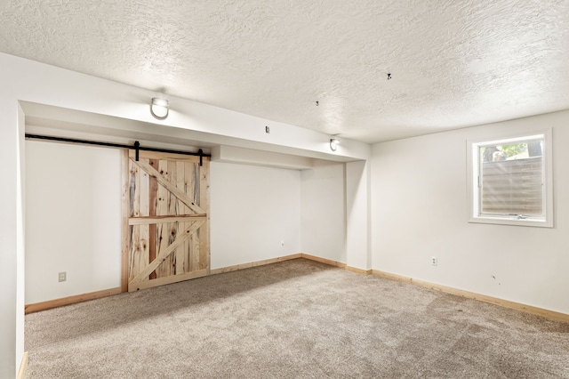 122 22nd St S, Great Falls, MT 59401 - basement with carpet floors, baseboards, a textured ceiling, and a barn door