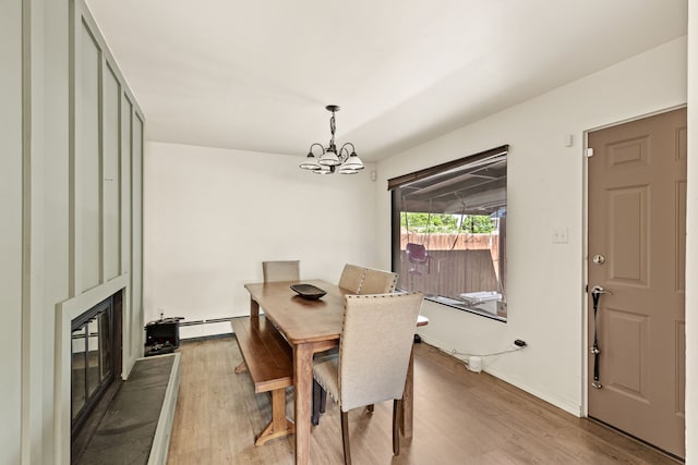 122 22nd St S, Great Falls, MT 59401 - dining room with light wood-type flooring, a chandelier, a large fireplace, and a baseboard radiator