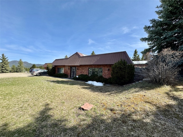 55 Equis Ln, Butte, MT 59701 - view of side of home featuring a lawn, metal roof, brick siding, and a standing seam roof