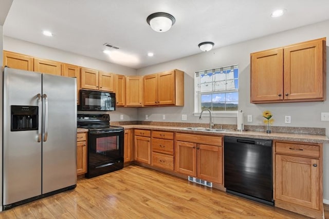 8 Mitchell Way, Columbia Falls, MT 59912 - kitchen with black dishwasher, stainless steel fridge with ice dispenser, an AC wall unit, a sink, and light wood-type flooring