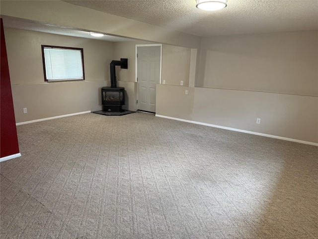 2720 Bandera Dr, East Helena, MT 59635 - unfurnished living room with a wood stove, carpet floors, a textured ceiling, and baseboards
