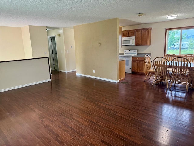 2720 Bandera Dr, East Helena, MT 59635 - kitchen with white appliances, brown cabinets, a textured ceiling, dark wood-style floors, and open floor plan