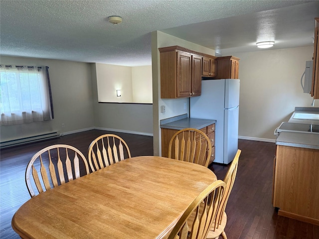2720 Bandera Dr, East Helena, MT 59635 - dining area with a baseboard heating unit, dark wood finished floors, baseboards, and a textured ceiling