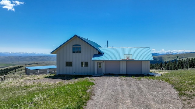 199 Mountain View Trl, White Sulphur Springs, MT 59645 - view of front facade with a mountain view, driveway, metal roof, and a garage