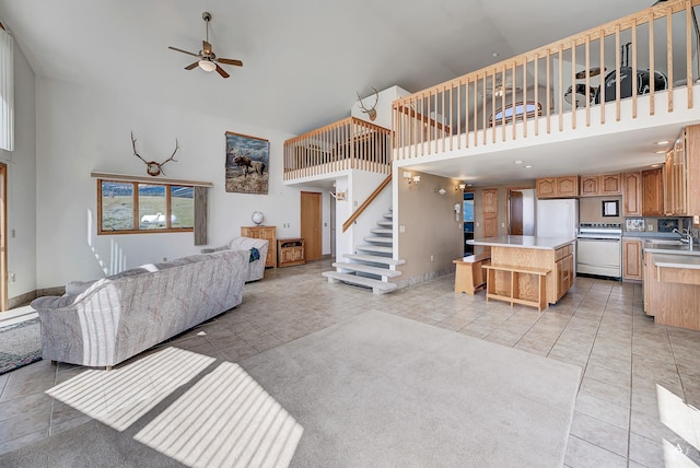 199 Mountain View Trl, White Sulphur Springs, MT 59645 - living room featuring high vaulted ceiling, a ceiling fan, stairway, light tile patterned floors, and baseboards