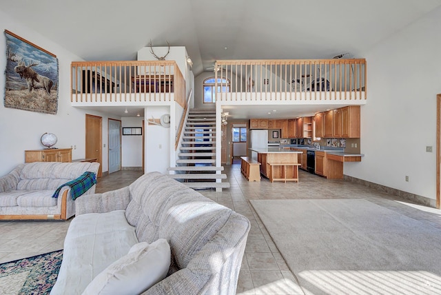 199 Mountain View Trl, White Sulphur Springs, MT 59645 - living area with high vaulted ceiling, stairs, light tile patterned floors, and baseboards