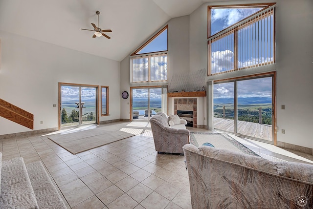 199 Mountain View Trl, White Sulphur Springs, MT 59645 - living area featuring high vaulted ceiling, ceiling fan, a tiled fireplace, light tile patterned floors, and baseboards