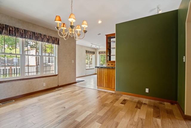 3721 Brandon Way, Missoula, MT 59803 - empty room featuring track lighting, a chandelier, light wood-style floors, and baseboards