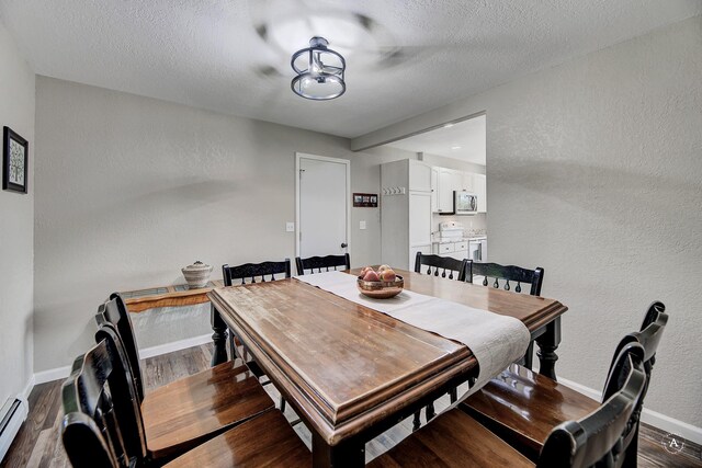2 N Oregon St, Helena, MT 59601 - dining space featuring a baseboard radiator, dark wood-type flooring, baseboards, a textured wall, and a textured ceiling
