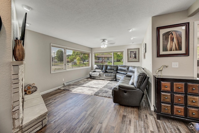 2 N Oregon St, Helena, MT 59601 - living room with baseboard heating, baseboards, wood finished floors, and a textured ceiling