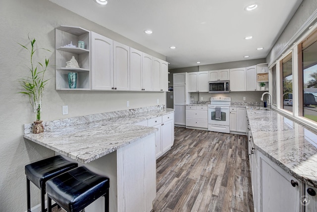 2 N Oregon St, Helena, MT 59601 - kitchen with white electric stove, open shelves, stainless steel microwave, light stone counters, and a peninsula