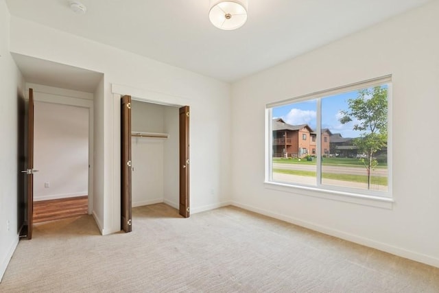 147 Hawthorne Ct Unit B, Whitefish, MT 59937 - unfurnished bedroom with light carpet, baseboards, and a closet