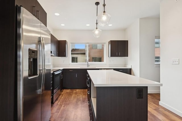 147 Hawthorne Ct Unit B, Whitefish, MT 59937 - kitchen featuring stainless steel appliances, light wood-style flooring, light countertops, hanging light fixtures, and a kitchen island