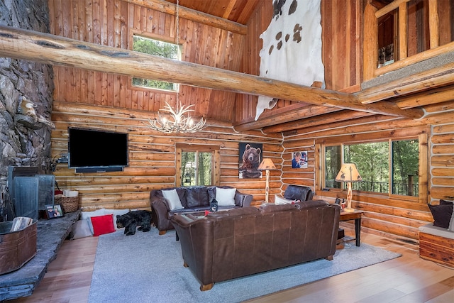 1835 Emmons Canyon Rd, Kila, MT 59920 - living room featuring healthy amount of natural light, a chandelier, wood-type flooring, high vaulted ceiling, and rustic walls