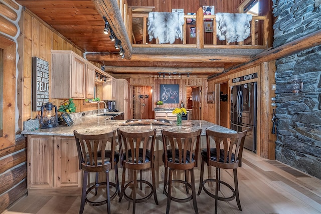 1835 Emmons Canyon Rd, Kila, MT 59920 - kitchen with freestanding refrigerator, a peninsula, a sink, wooden ceiling with exposed beams, and light wood-style floors