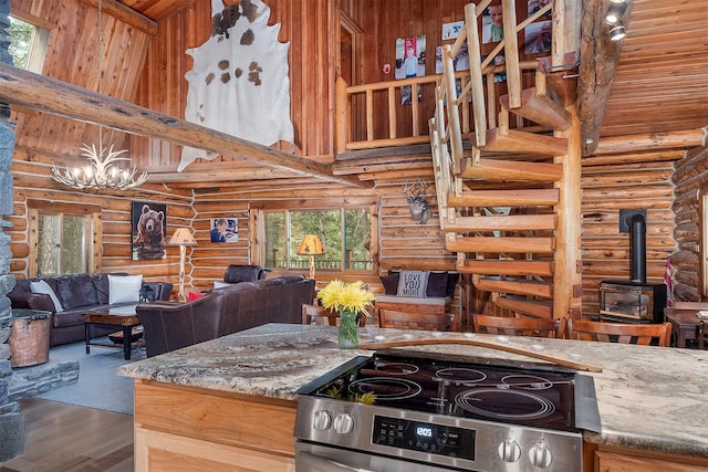 1835 Emmons Canyon Rd, Kila, MT 59920 - kitchen with stainless steel electric stove, log walls, a high ceiling, a chandelier, and plenty of natural light