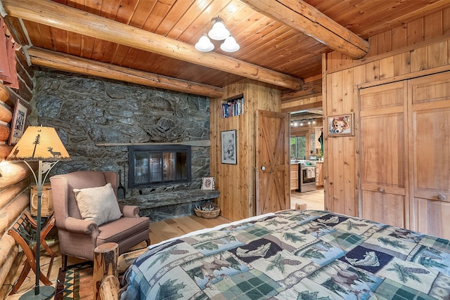 1835 Emmons Canyon Rd, Kila, MT 59920 - bedroom featuring wood ceiling with exposed beams, wood finished floors, a fireplace, and wooden walls
