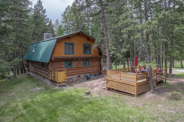 1835 Emmons Canyon Rd, Kila, MT 59920 - back of property with log exterior, a wooden deck, metal roof, and a chimney