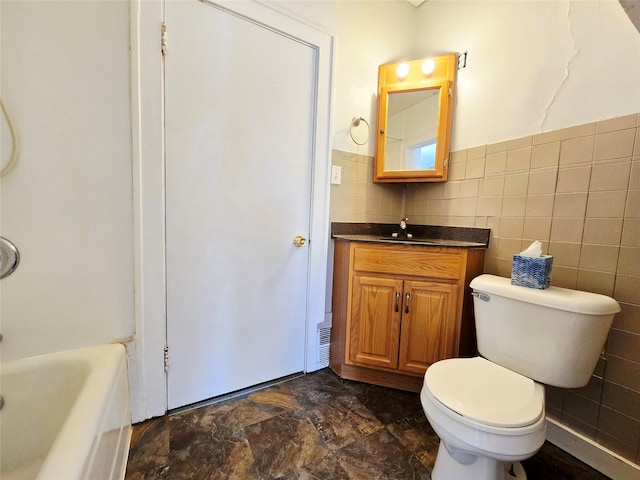 515 7th St N, Great Falls, MT 59401 - bathroom featuring vanity, a bath, toilet, and tile walls