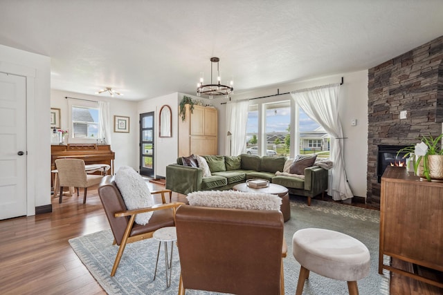 845 Mountain Vista Way, Kalispell, MT 59901 - living room with a chandelier, dark wood-style flooring, and a stone fireplace