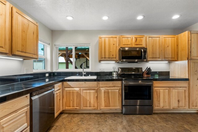 505 N 4th St, Hamilton, MT 59840 - kitchen with stainless steel appliances, a sink, recessed lighting, a textured ceiling, and tile countertops