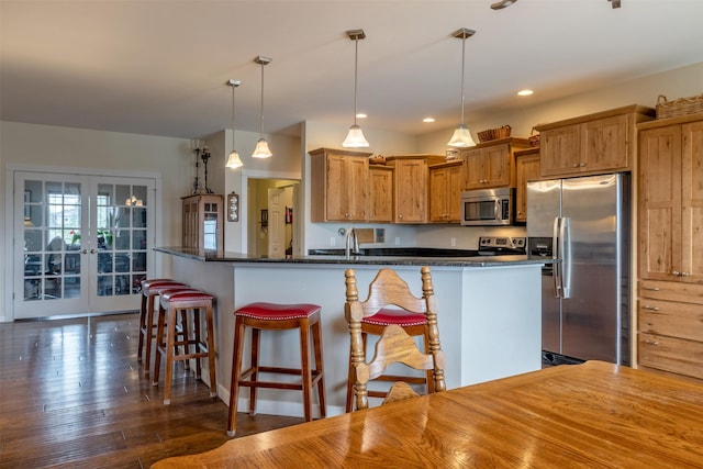 4288 Iverson Rd, Helena, MT 59602 - kitchen featuring stainless steel appliances, a kitchen bar, pendant lighting, brown cabinetry, and dark wood-style floors