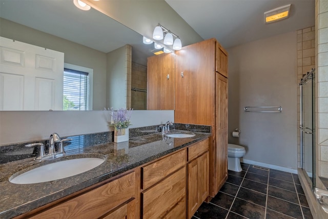 4288 Iverson Rd, Helena, MT 59602 - bathroom featuring a tile shower, double vanity, toilet, tile patterned flooring, and baseboards