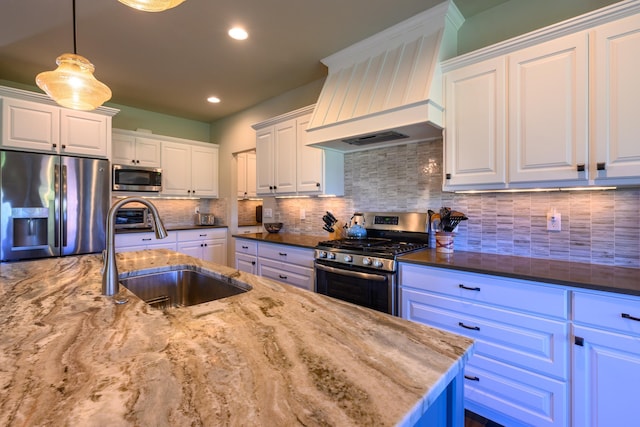 135 E Swift Creek Way, Kalispell, MT 59901 - kitchen featuring stainless steel appliances, custom range hood, dark stone countertops, white cabinets, and recessed lighting