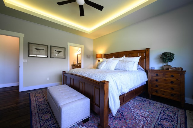 135 E Swift Creek Way, Kalispell, MT 59901 - bedroom with a raised ceiling, dark wood-type flooring, baseboards, ceiling fan, and connected bathroom