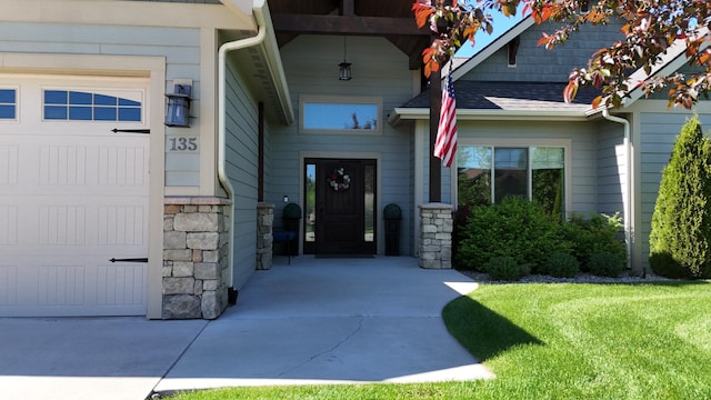 135 E Swift Creek Way, Kalispell, MT 59901 - view of exterior entry with stone siding, a yard, and a shingled roof
