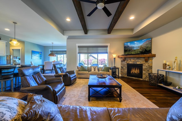 135 E Swift Creek Way, Kalispell, MT 59901 - living area with wood finished floors, a ceiling fan, a stone fireplace, beamed ceiling, and recessed lighting