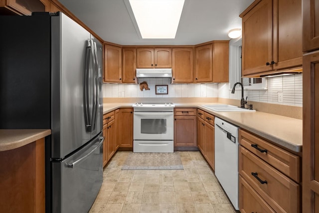 343 Deer Trl, Whitefish, MT 59937 - kitchen with white appliances, a sink, under cabinet range hood, tasteful backsplash, and brown cabinetry